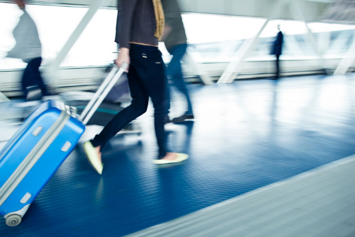 Woman rushing with suitcase at airport